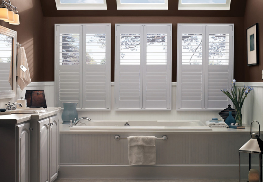 The image depicts a bathroom with white shuttered windows, a white bathtub, and a beige tiled floor.