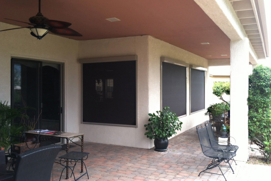 The image shows a covered patio area with sliding glass doors, adjacent to a house.